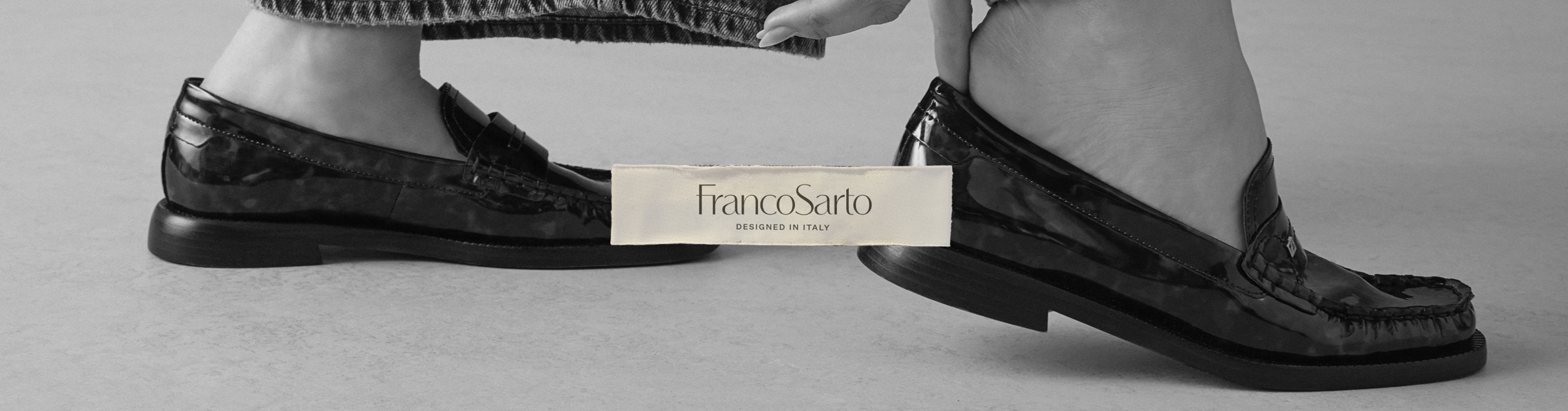 A woman slipping on a pair of tortoise-print patent leather loafers. The Franco Sarto logo is overlaid.