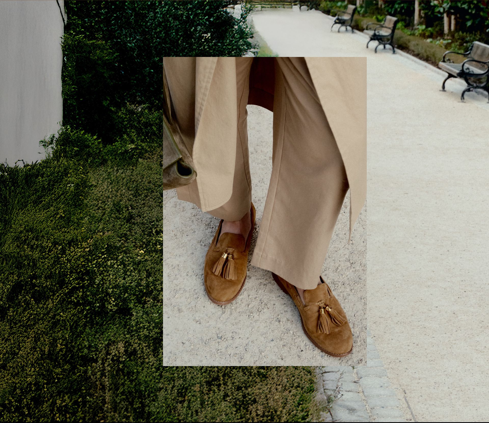 Franco Sarto Hartlie Tassel Loafer in tan suede styled with wide-leg tan trousers on a garden path