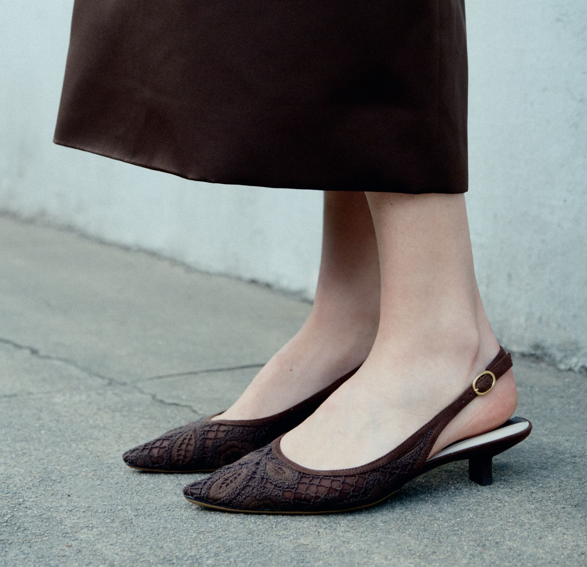 Franco Sarto Pura Slingback in brown crocheted fabric with pointed toe and kitten heel, worn with a dark brown midi skirt.