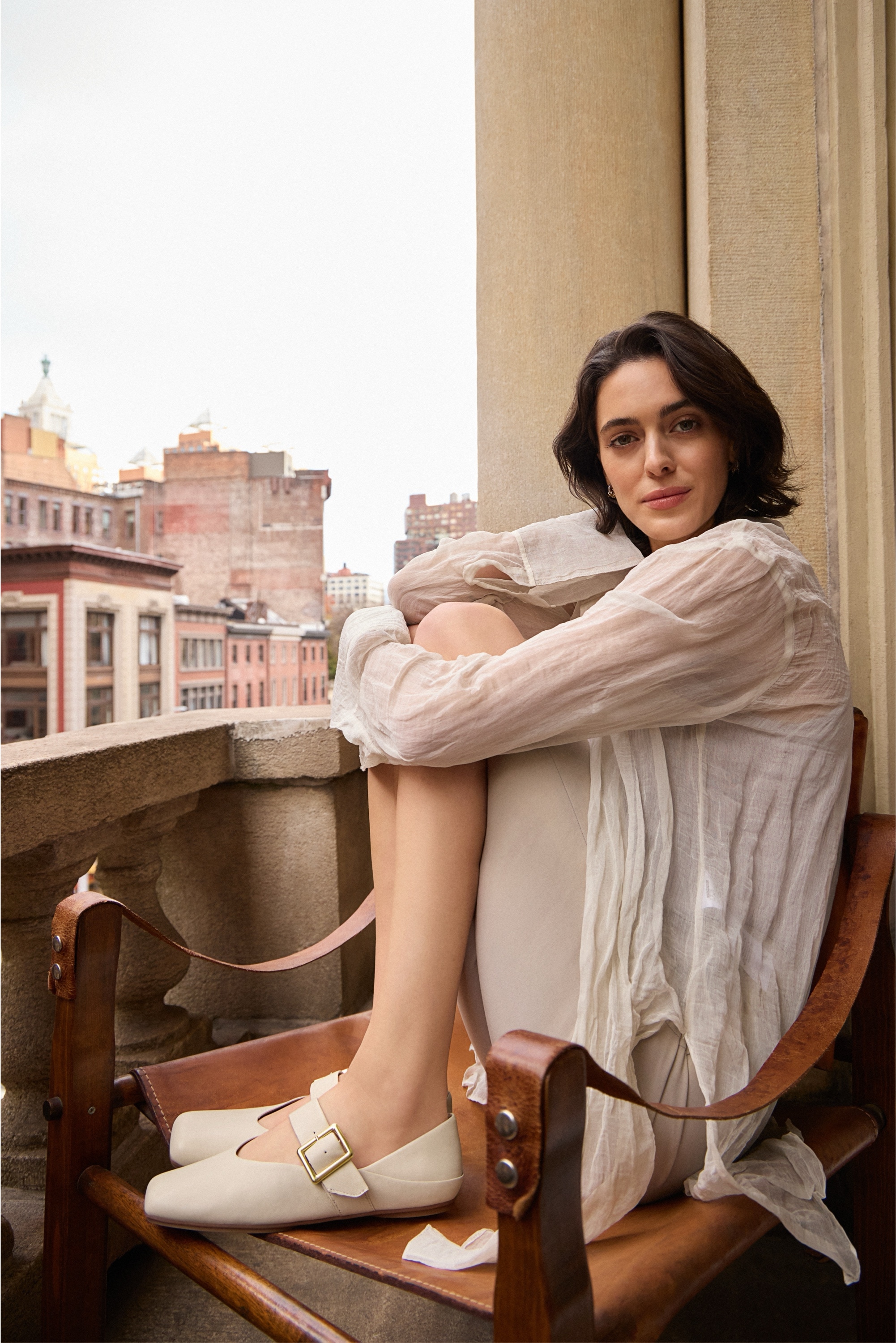 a woman sitting on her patio wearing the oakes mary jane loafer in ivory beige