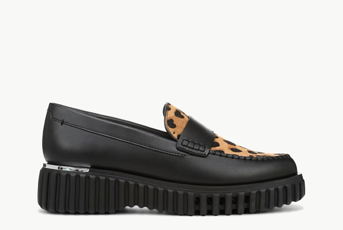 Side view of a women’s black lug sole loafer with a leopard print vamp. 